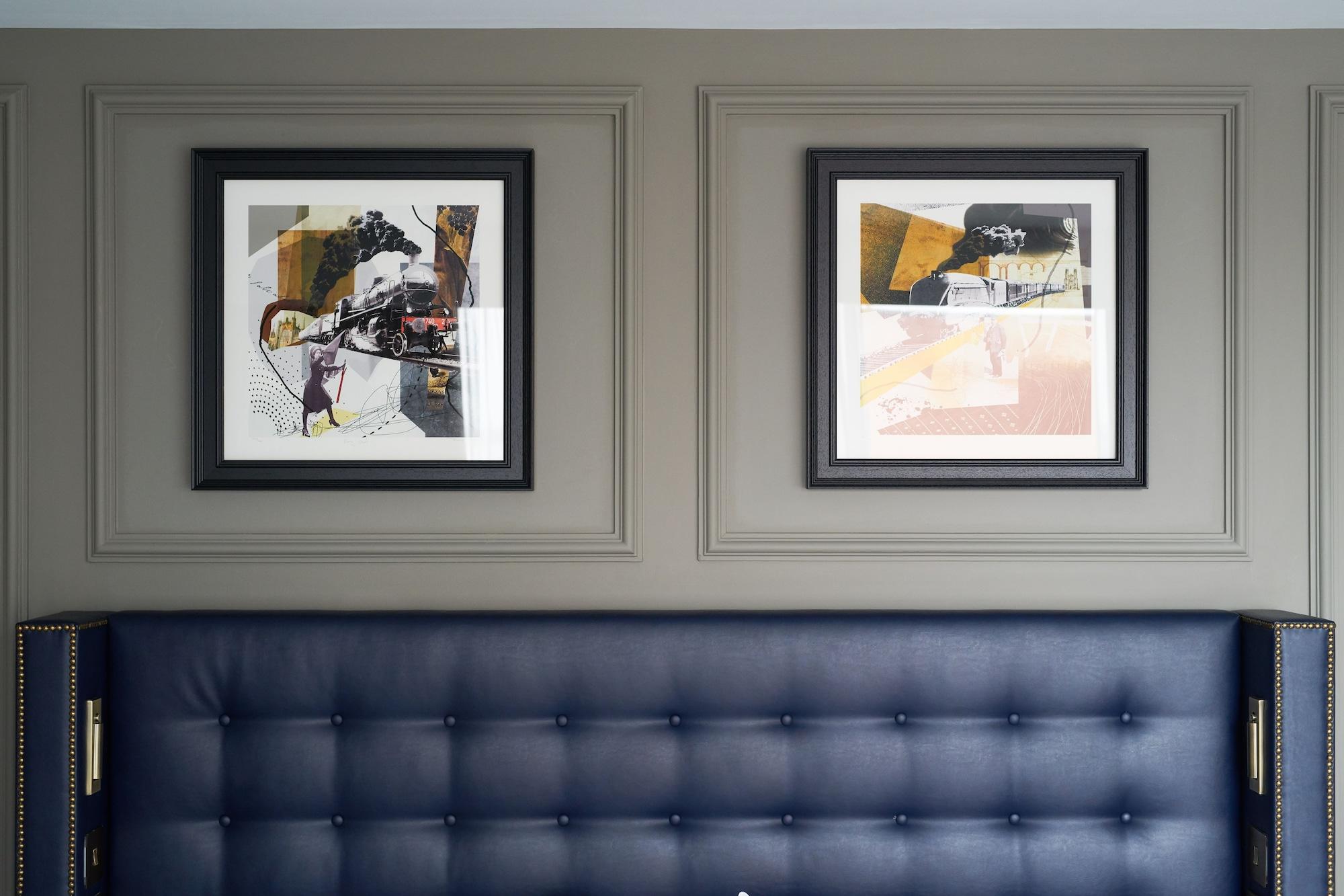 The Grand, York Hotel Exterior photo The photo showcases a wall with two framed artworks hung above a stylish headboard. The wall has a muted green color and features decorative molding. The headboard is upholstered in dark blue with a tufted design. Each artwork has a black frame and a