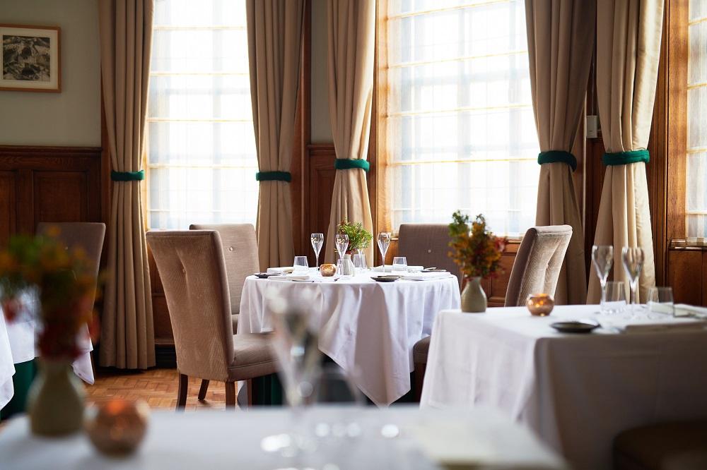 The Grand, York Hotel Exterior photo The photo shows a tastefully arranged dining area in a restaurant. The tables are covered with white tablecloths, and there are elegant chairs positioned around them. A couple of tables have empty wine glasses and decorative centerpieces with flowers