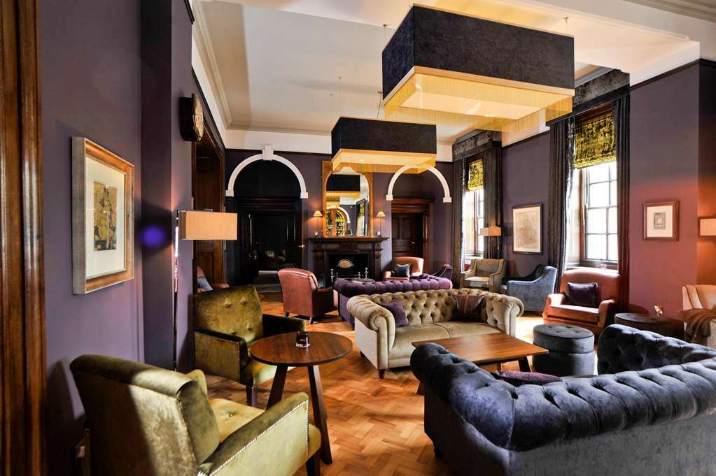 The Grand, York Hotel Interior photo The photo showcases a stylish and elegant lounge or living area. The interior features a rich color palette with dark walls and plush furniture. There are several seating options, including a large tufted sofa and armchairs in various colors like gre